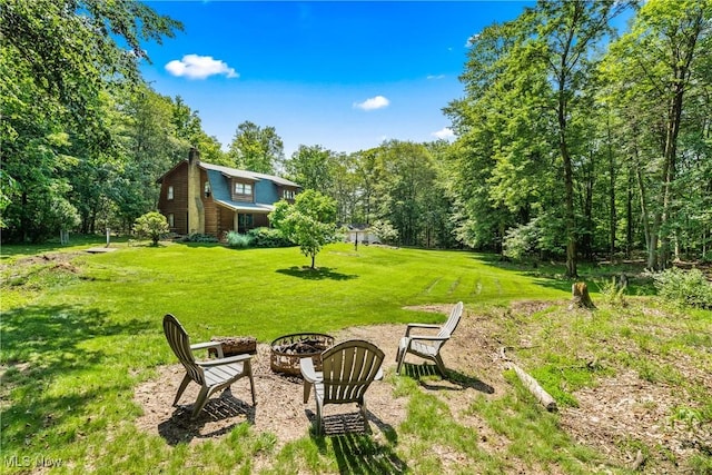 15961 Terramont St NE, Minerva, OH 44657 - view of grassy yard with a fire pit and a forest view
