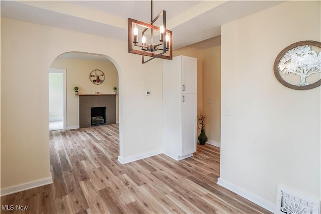 1967 Tonawanda Ave, Akron, OH 44305 - unfurnished dining area with arched walkways, light wood finished floors, and a chandelier