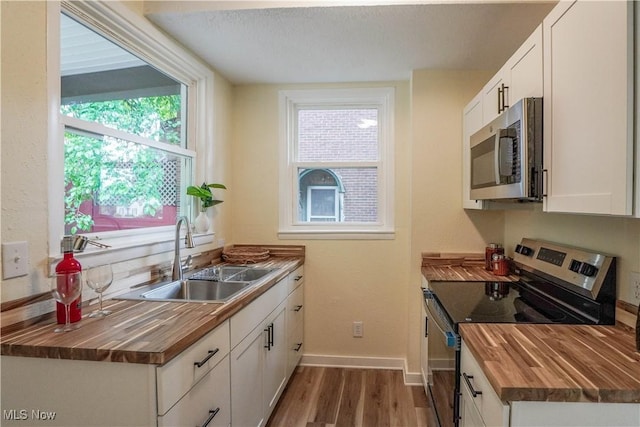 1967 Tonawanda Ave, Akron, OH 44305 - kitchen featuring appliances with stainless steel finishes, butcher block countertops, wood finished floors, and white cabinetry