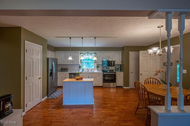 106 Wedgewood Dr, Parkersburg, WV 26104 - kitchen with stainless steel appliances, a chandelier, dark wood-style flooring, and a kitchen island