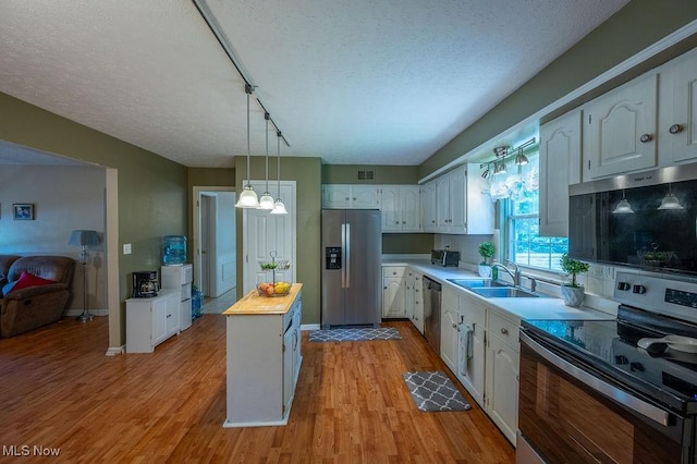 106 Wedgewood Dr, Parkersburg, WV 26104 - kitchen featuring appliances with stainless steel finishes, white cabinetry, butcher block countertops, light wood finished floors, and a textured ceiling