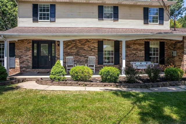 106 Wedgewood Dr, Parkersburg, WV 26104 - view of front of home with a porch, a front yard, brick siding, and a shingled roof
