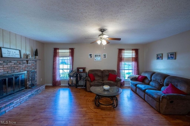 106 Wedgewood Dr, Parkersburg, WV 26104 - living room with wood finished floors, a textured ceiling, a ceiling fan, and a brick fireplace