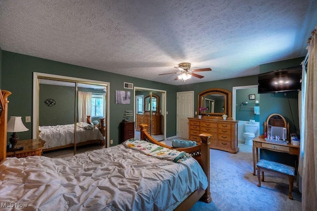 106 Wedgewood Dr, Parkersburg, WV 26104 - bedroom with two closets, light carpet, a textured ceiling, ceiling fan, and ensuite bath