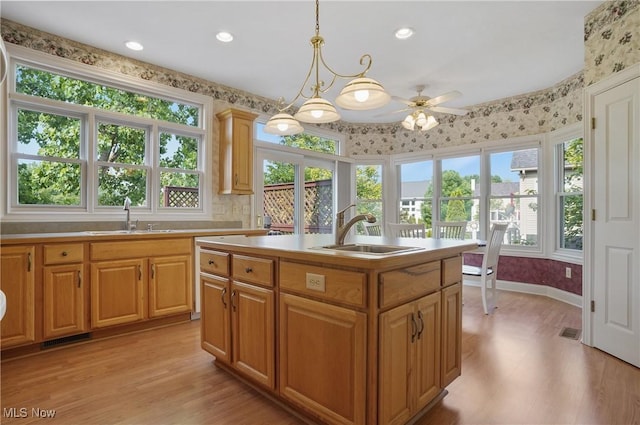 1288 Windward Ln, Kent, OH 44240 - kitchen featuring light wood-style flooring, ceiling fan, light countertops, an island with sink, and pendant lighting