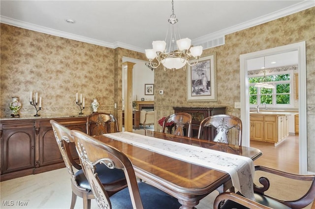 1288 Windward Ln, Kent, OH 44240 - dining area with a chandelier, wallpapered walls, ornamental molding, ornate columns, and light wood-style floors