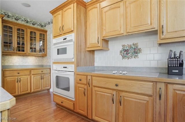 1288 Windward Ln, Kent, OH 44240 - kitchen featuring light countertops, decorative backsplash, glass insert cabinets, and light wood-style flooring