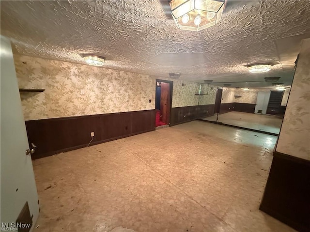 522 N 3rd St, Toronto, OH 43964 - spare room with a wainscoted wall, wallpapered walls, tile patterned floors, and wood walls