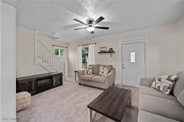 326 N Park Ave, Alliance, OH 44601 - carpeted living area with stairway, a textured ceiling, and a ceiling fan