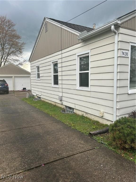 7438 Westview Dr, Youngstown, OH 44512 - view of side of property with a detached garage, an outbuilding, and board and batten siding