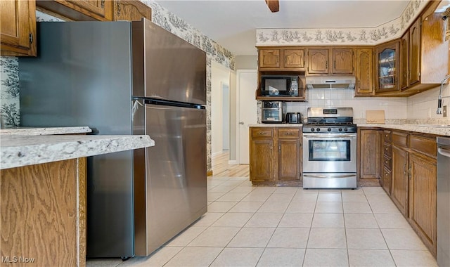 1701 19th Ave, Parkersburg, WV 26101 - kitchen with appliances with stainless steel finishes, under cabinet range hood, brown cabinets, and light countertops