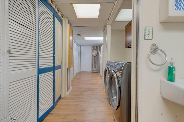 1701 19th Ave, Parkersburg, WV 26101 - washroom with independent washer and dryer, light wood-style flooring, and cabinet space