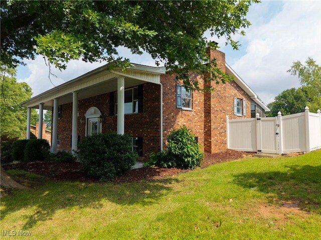 1701 19th Ave, Parkersburg, WV 26101 - view of home's exterior featuring brick siding, a gate, a chimney, and a porch