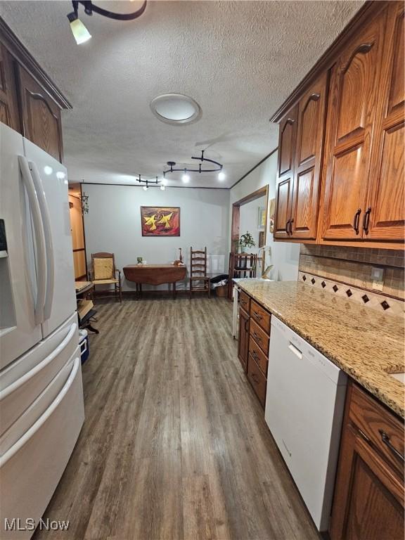 7261 Austin Dr, Mcconnelsville, OH 43756 - kitchen with freestanding refrigerator, dishwasher, dark wood finished floors, backsplash, and light stone counters