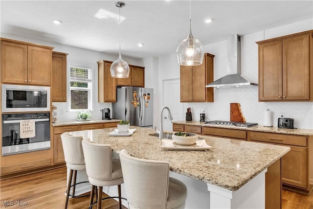 23200 St Andrews Dr, Columbia Station, OH 44028 - kitchen featuring stainless steel appliances, wall chimney exhaust hood, brown cabinets, and recessed lighting