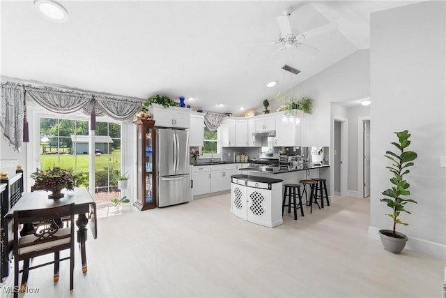 14203 Hatfield Rd, Rittman, OH 44270 - kitchen with appliances with stainless steel finishes, dark countertops, a peninsula, a ceiling fan, and a kitchen breakfast bar