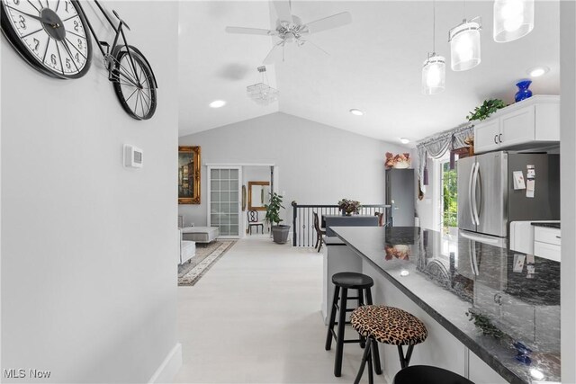 14203 Hatfield Rd, Rittman, OH 44270 - kitchen featuring freestanding refrigerator, a breakfast bar, white cabinetry, lofted ceiling, and recessed lighting