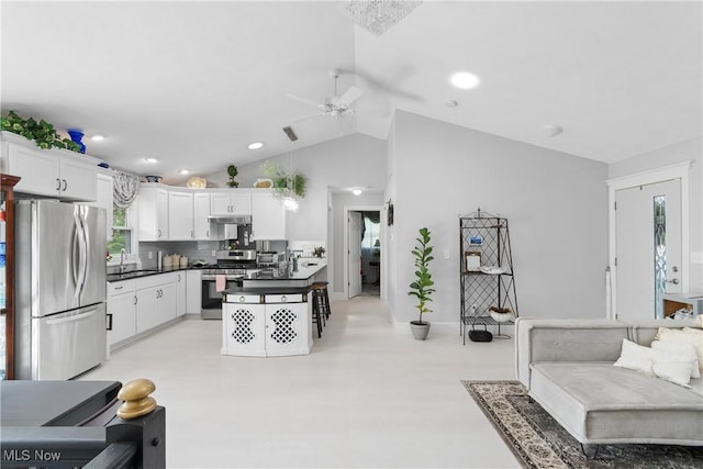 14203 Hatfield Rd, Rittman, OH 44270 - kitchen featuring stainless steel appliances, dark countertops, ceiling fan, white cabinetry, and decorative backsplash
