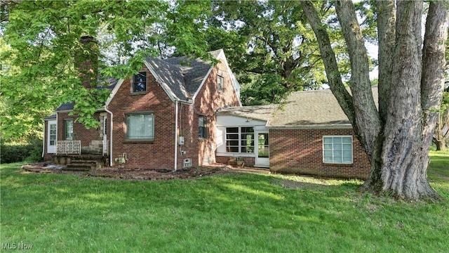 2335 Southway St SW, Massillon, OH 44646 - english style home featuring brick siding, a front yard, a chimney, and a shingled roof