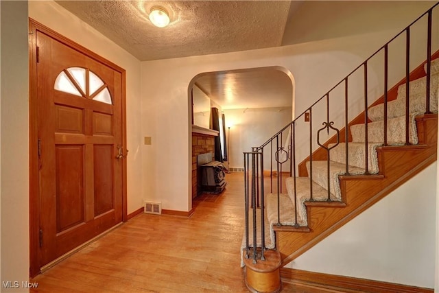 2335 Southway St SW, Massillon, OH 44646 - entryway featuring wood finished floors, stairway, arched walkways, and a textured ceiling