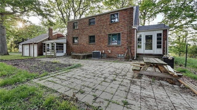 2335 Southway St SW, Massillon, OH 44646 - rear view of house featuring brick siding, a patio area, a sunroom, and an attached garage