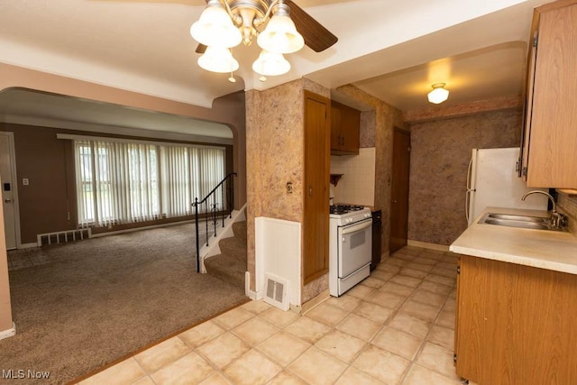 1114 W Miner Rd, Mayfield Heights, OH 44124 - kitchen featuring white appliances, light countertops, light colored carpet, ceiling fan, and brown cabinetry