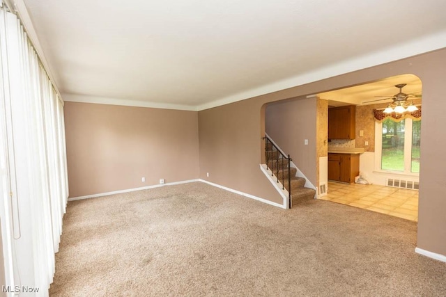 1114 W Miner Rd, Mayfield Heights, OH 44124 - unfurnished living room with carpet, stairway, ceiling fan, and arched walkways