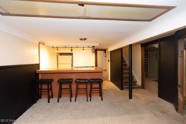 1114 W Miner Rd, Mayfield Heights, OH 44124 - indoor bar with freestanding refrigerator, wainscoting, stairway, and light carpet