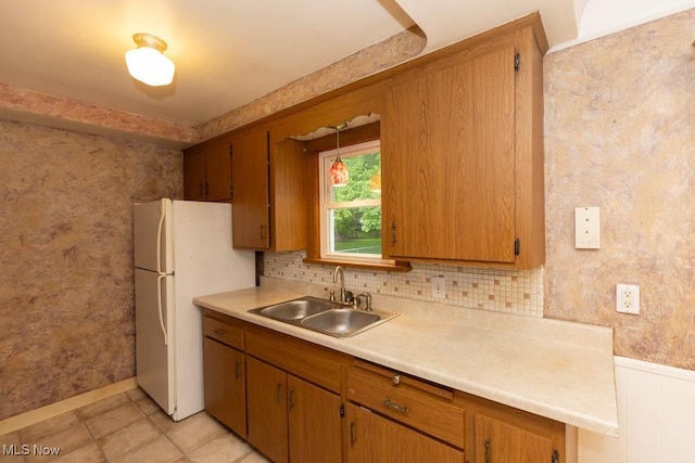 1114 W Miner Rd, Mayfield Heights, OH 44124 - kitchen with freestanding refrigerator, light countertops, brown cabinetry, light tile patterned flooring, and tasteful backsplash