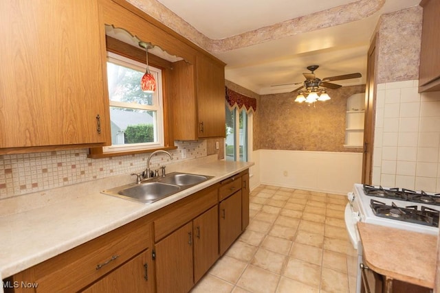 1114 W Miner Rd, Mayfield Heights, OH 44124 - kitchen featuring white gas stove, light countertops, a ceiling fan, decorative light fixtures, and brown cabinets