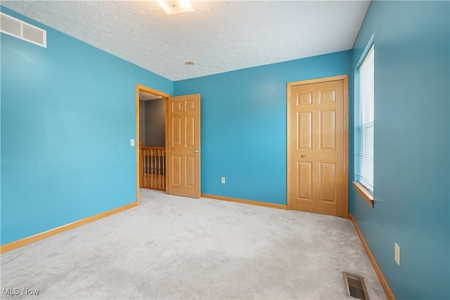 2919 Pepper Hill Cir, Akron, OH 44312 - unfurnished bedroom with multiple windows, carpet, and a textured ceiling