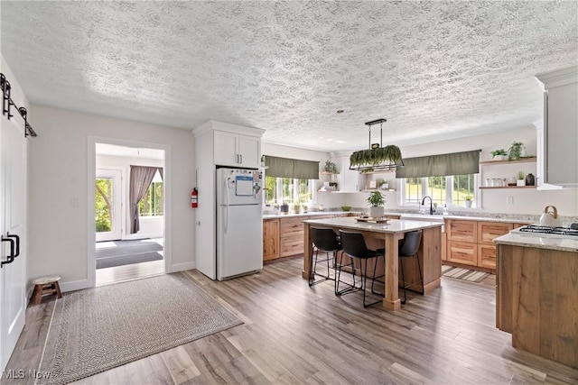 59301 Honeybee Rd, Senecaville, OH 43780 - kitchen featuring freestanding refrigerator, open shelves, plenty of natural light, and a textured ceiling