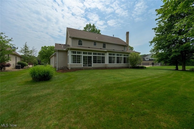 1015 Cambridge Ct NE, Warren, OH 44484 - back of property featuring a chimney, a lawn, and a sunroom