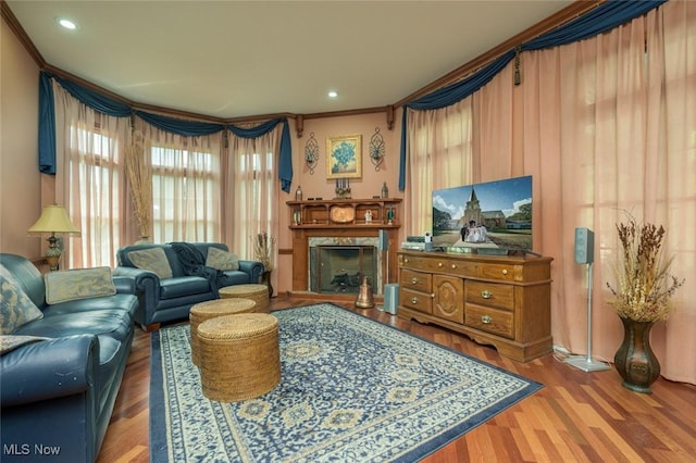 1015 Cambridge Ct NE, Warren, OH 44484 - living area featuring wood finished floors, healthy amount of natural light, a high end fireplace, crown molding, and recessed lighting