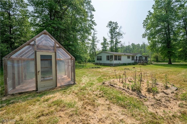 2500 Mcclintocksburg Rd, Deerfield, OH 44411 - view of grassy yard featuring a greenhouse, an outdoor structure, and view of wooded area