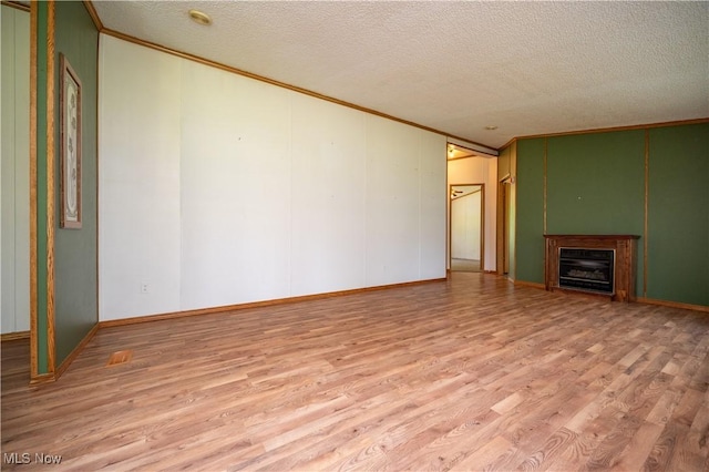 2500 Mcclintocksburg Rd, Deerfield, OH 44411 - unfurnished living room with ornamental molding, wood finished floors, a textured ceiling, a decorative wall, and a fireplace