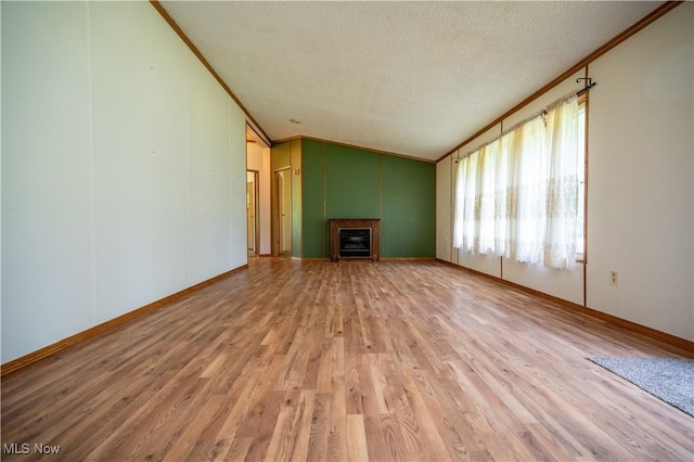 2500 Mcclintocksburg Rd, Deerfield, OH 44411 - unfurnished living room with ornamental molding, a textured ceiling, light wood-type flooring, lofted ceiling, and a fireplace