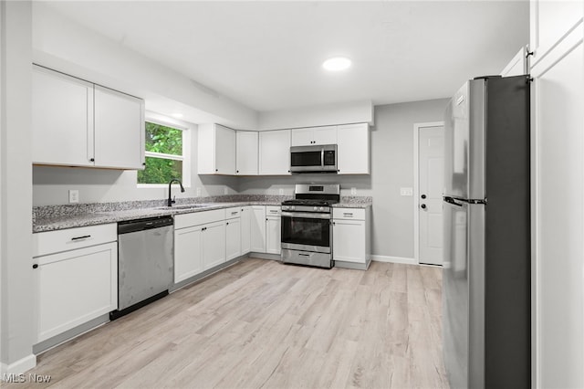 4232 Wilson Rd, Ravenna, OH 44266 - kitchen with stainless steel appliances, light wood-type flooring, white cabinetry, light stone countertops, and recessed lighting
