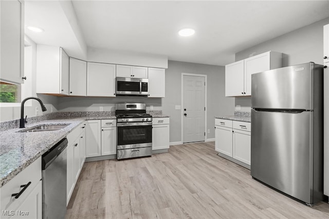 4232 Wilson Rd, Ravenna, OH 44266 - kitchen featuring appliances with stainless steel finishes, white cabinetry, light wood-style floors, light stone countertops, and recessed lighting