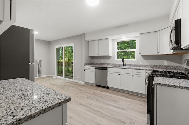 4232 Wilson Rd, Ravenna, OH 44266 - kitchen featuring appliances with stainless steel finishes, light wood finished floors, light stone countertops, healthy amount of natural light, and recessed lighting