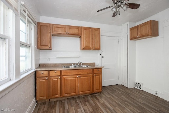 11515 Hopkins Ave, Cleveland, OH 44108 - kitchen with dark wood finished floors, brown cabinetry, a ceiling fan, and light countertops