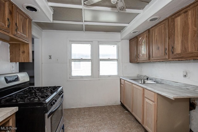 11515 Hopkins Ave, Cleveland, OH 44108 - kitchen with stainless steel range with gas cooktop, light countertops, and brown cabinets
