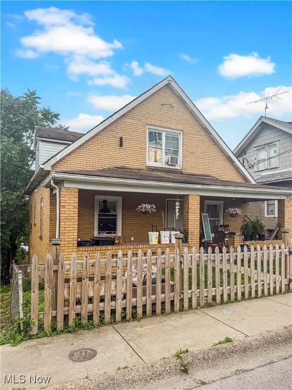 114 S 12th St, Weirton, WV 26062 - view of front of property featuring a porch, brick siding, and a fenced front yard