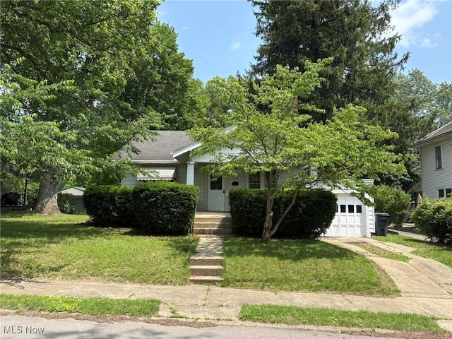 105 S Maple Hts, New Lexington, OH 43764 - view of property hidden behind natural elements with concrete driveway, a front lawn, and an attached garage