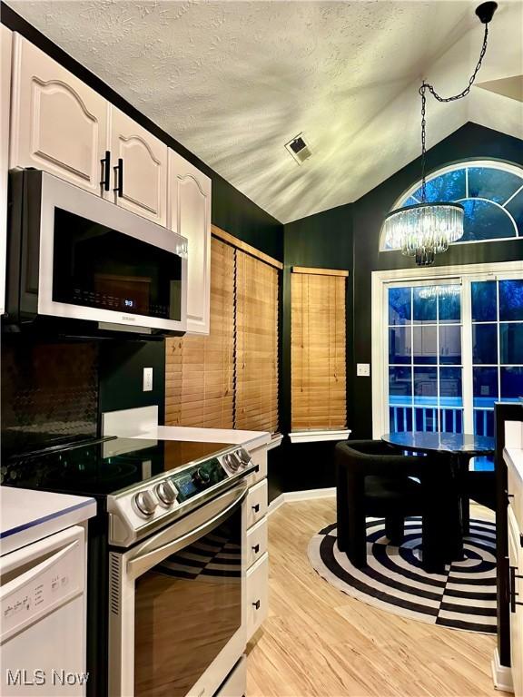 194 Vista Cir, North Olmsted, OH 44070 - kitchen featuring appliances with stainless steel finishes, white cabinetry, light wood-style floors, a chandelier, and pendant lighting