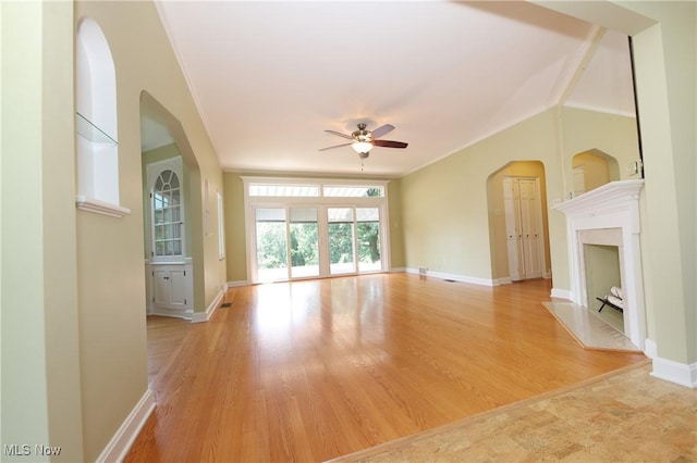 3901 Beaumont Dr, Weirton, WV 26062 - unfurnished living room with a ceiling fan, arched walkways, ornamental molding, a premium fireplace, and light wood finished floors
