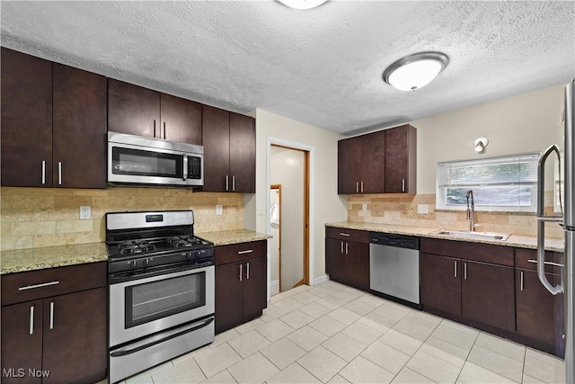 792 Miner Rd, Highland Heights, OH 44143 - kitchen with appliances with stainless steel finishes, tasteful backsplash, light stone counters, dark brown cabinets, and light tile patterned floors
