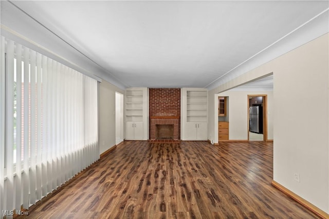 792 Miner Rd, Highland Heights, OH 44143 - unfurnished living room with built in shelves, healthy amount of natural light, wood finished floors, and a fireplace