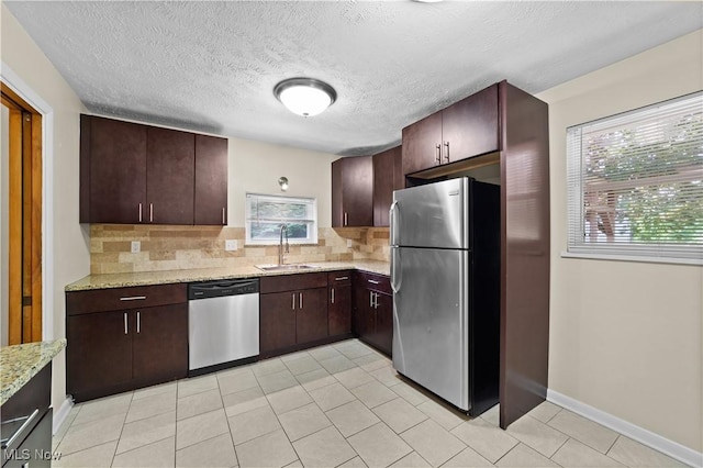 792 Miner Rd, Highland Heights, OH 44143 - kitchen featuring appliances with stainless steel finishes, backsplash, light stone countertops, dark brown cabinets, and a textured ceiling
