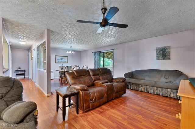 3378 State Route 164, Leetonia, OH 44431 - living room with light wood-style flooring, a textured ceiling, a chandelier, and ceiling fan